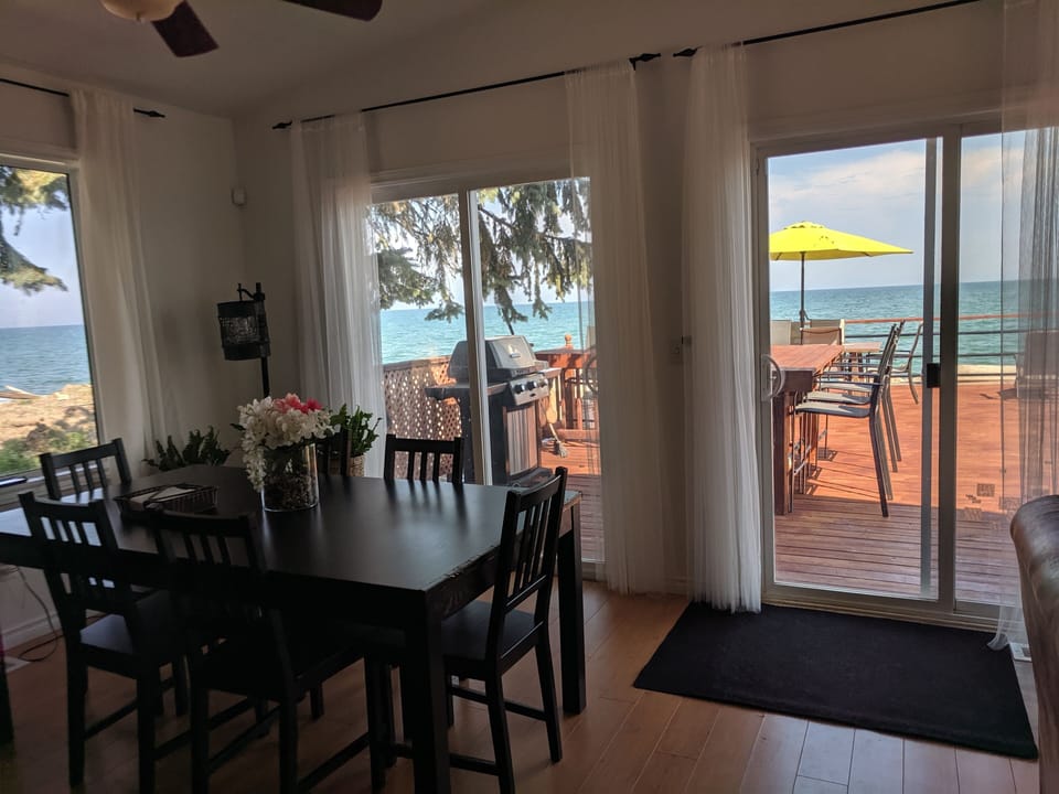 Dining area with large windows looking onto the lake on both sides.