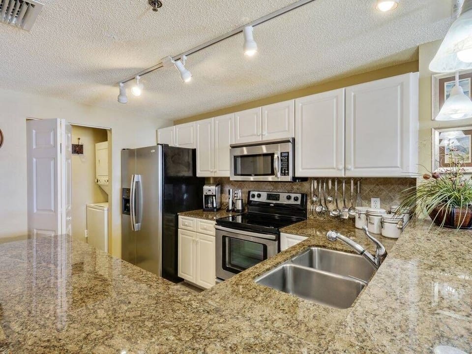 Full size stainless appliances including a dishwasher and washer/dryer.