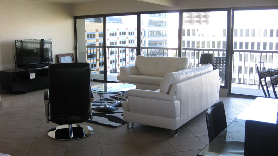 Living area and more windows/doors to balcony.