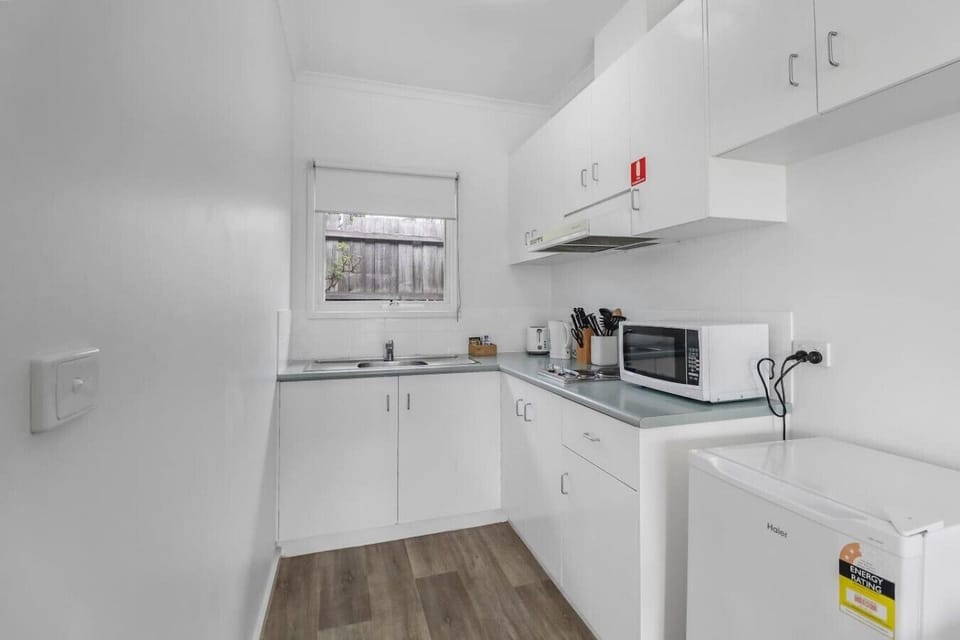 Compact kitchenette with fridge, microwave and essentials for easy self-catering stays.