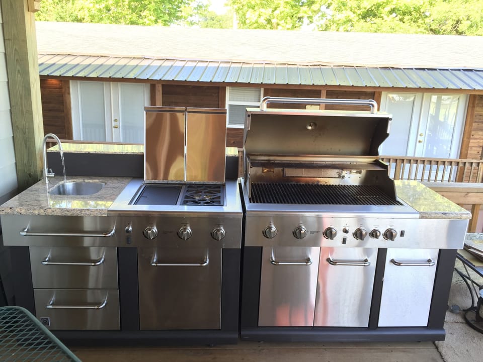 Full outdoor kitchen, with pancake grill, water and larger gas grill.