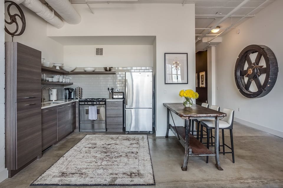 Kitchen with Breakfast Bar, Stools, Refrigerator, Toaster, and Coffee Maker.