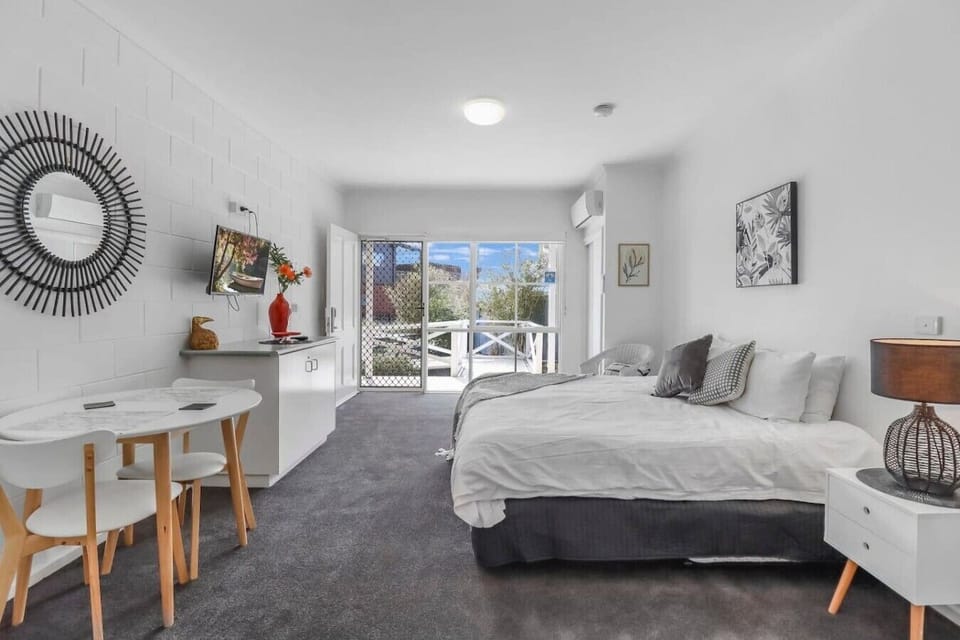Relaxing sleeping area with plush bedding and natural light in this Geelong studio stay.