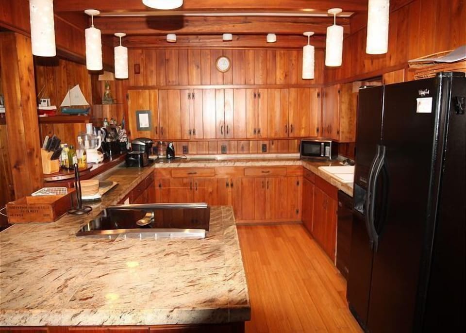 Rustic kitchen with rich wooden cabinetry and modern appliances.