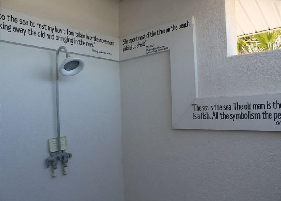Outdoor shower area with inspirational ocean-themed quotes.