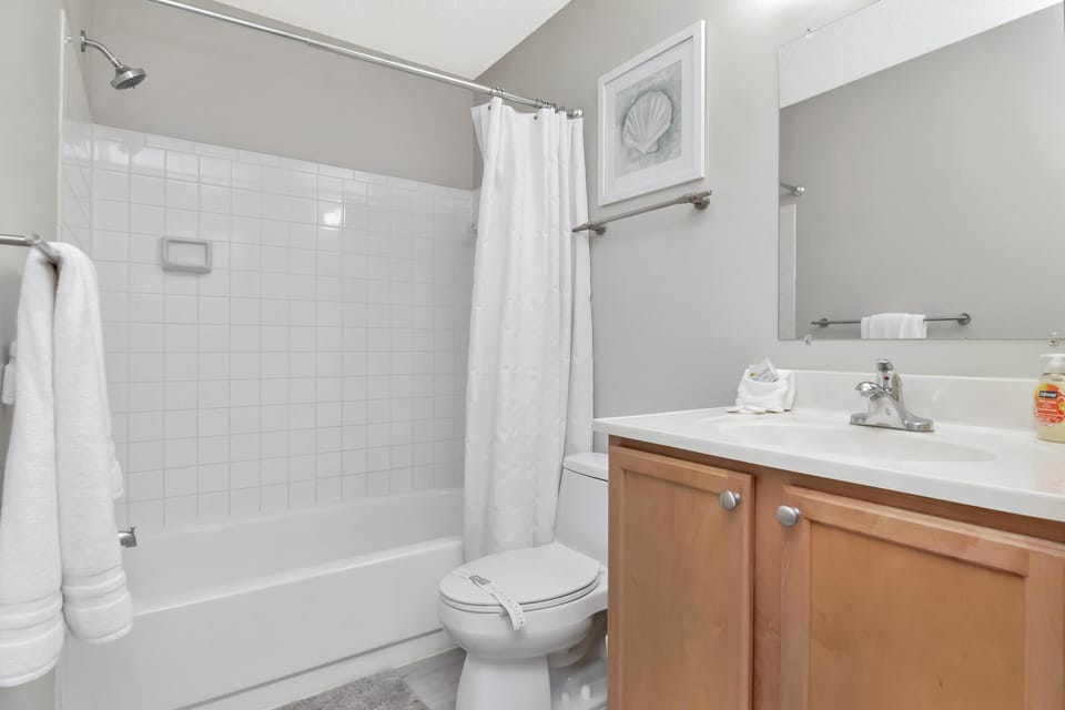Bright and clean bathroom with modern fixtures and tub-shower combo