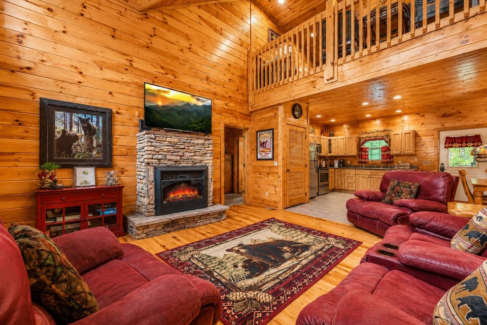 A charming brick electric fireplace anchors this inviting space, complete with a reclining sofa, rocker, and recliner for ultimate mountain‑retreat comfort