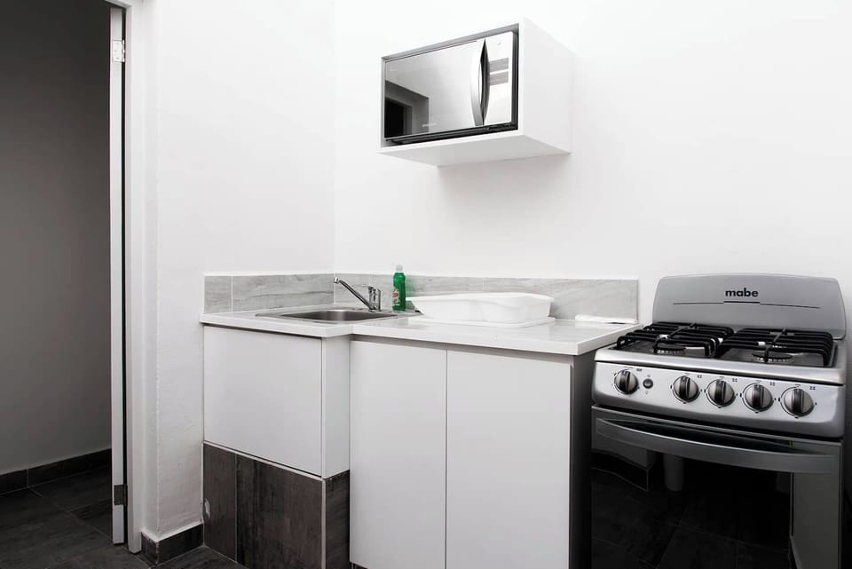 Kitchen with microwave, stove, refrigerator and kitchen supplies