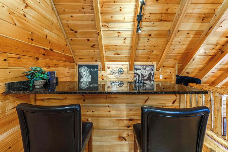 This elegant wet bar includes a polished granite counter and a built‑in refrigerator, creating a seamless space for mixing drinks for your family and friends