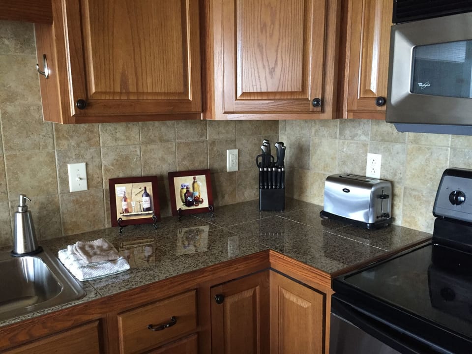 Kitchen has beautiful granite tile counters and stainless steel appliances 