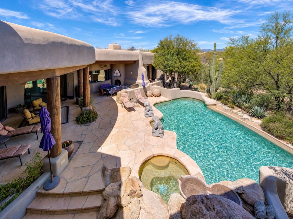 View of the pool, hot tub, back patio area from balcony above. Lots of privacy!