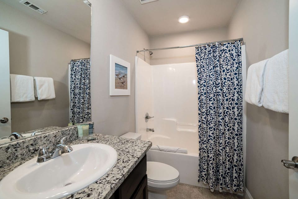 Guest bath has granite counter and shower/tub