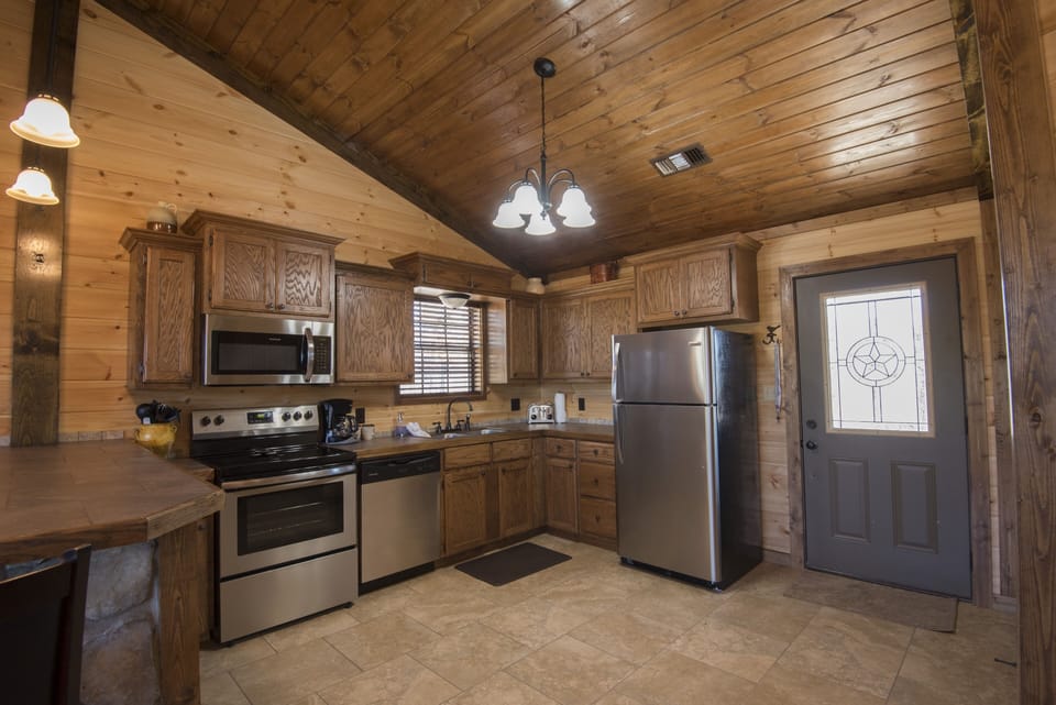 Kitchen With Amenities Refrigerator Stove Wash Basin Bar Table Shelves