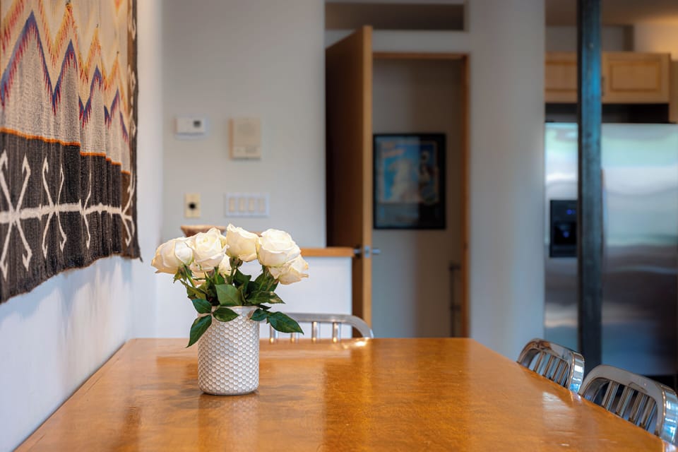 Dining - Bright interior featuring a dining table, artwork, and a view toward the kitchen.