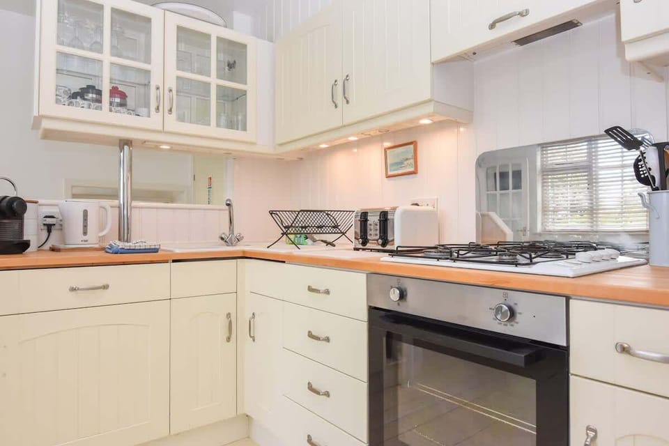 Detail shot of kitchen appliances at Mulberry Cottage including coffee machine, oven, fridge and dishwasher.
