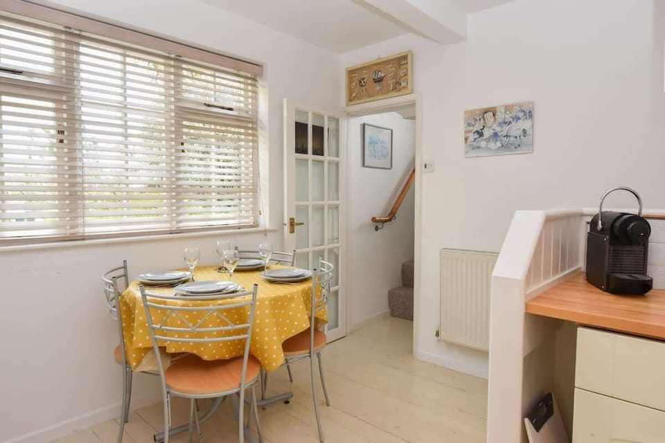 Open-plan kitchen and dining area at Mulberry Cottage featuring modern appliances and seating for meals together.
