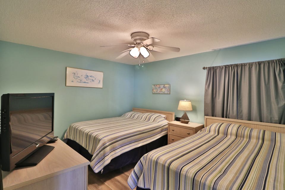 2nd bedroom with two queen size beds and a flat screen.