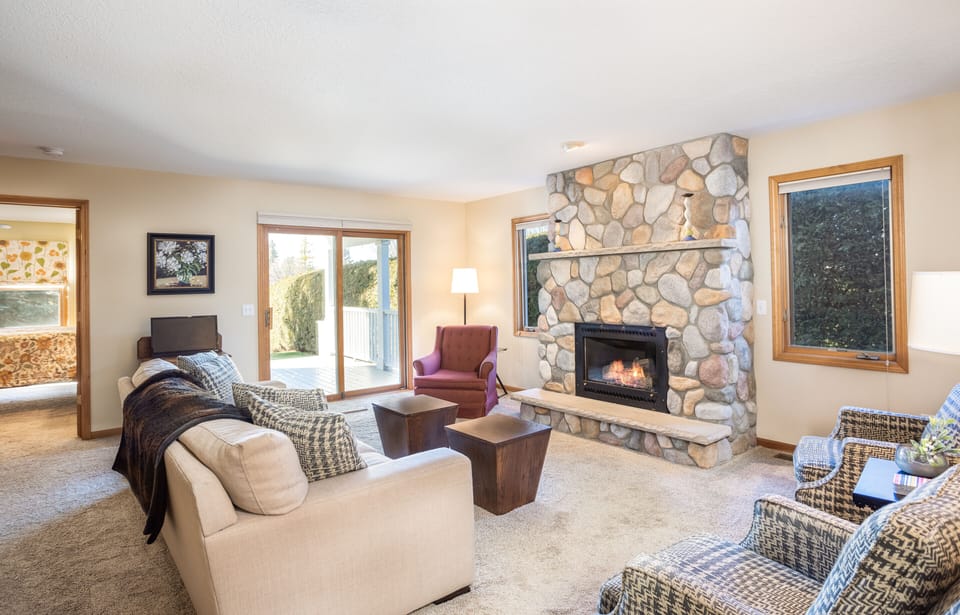 Open concept large living room with gas fireplace and views of Lake Leelanau 