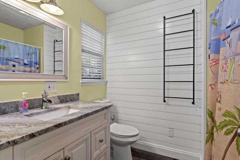 Step into our spacious bathroom adorned with a generously sized mirror, offering ample space to pamper yourself and prepare for the day ahead with ease and comfort.