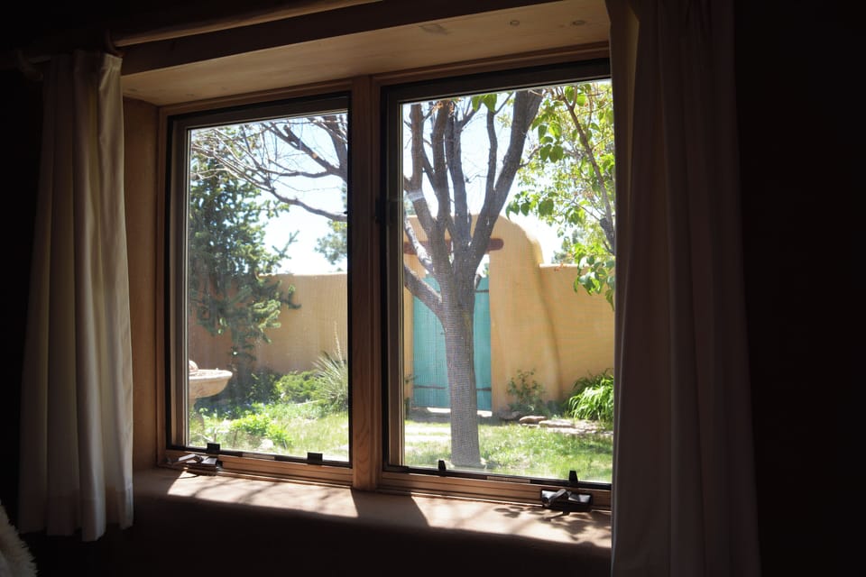 View from twin guest bedroom to adobe wall front patio