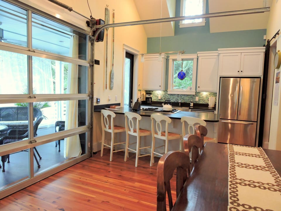 High-end kitchen with dining room that opens to the porch through garage doors