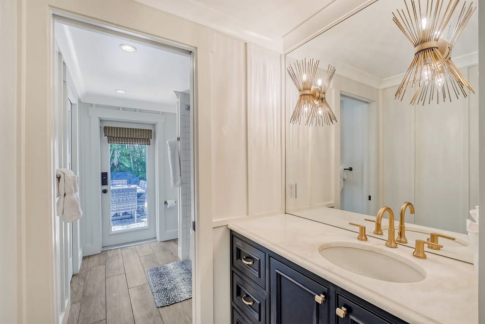 This bathroom door leads directly to the pool.  The sink vanity was separated from the shower/toilet area for privacy and improved flow for families.  This allows more than one person to get ready at a time.