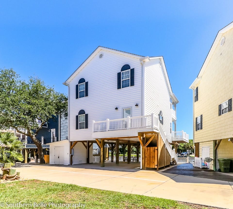 Front of House with parking area under home.