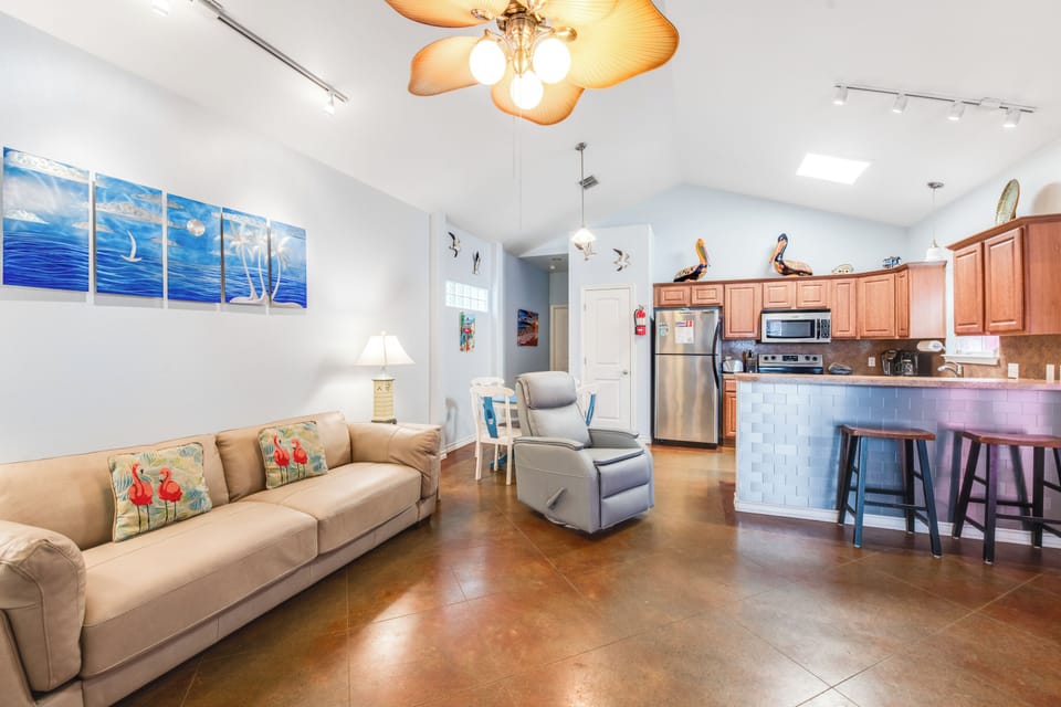 Settle into this bright open living space where coastal artwork and comfortable seating create your perfect home base for relaxation.
