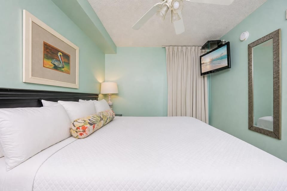 Fluffy pillows invite you to relax in the king suite for a calm movie night after a fun day at the beach