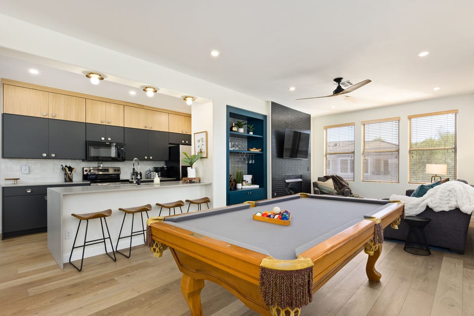 Kitchen with breakfast bar, pool table, wine bar, and living space