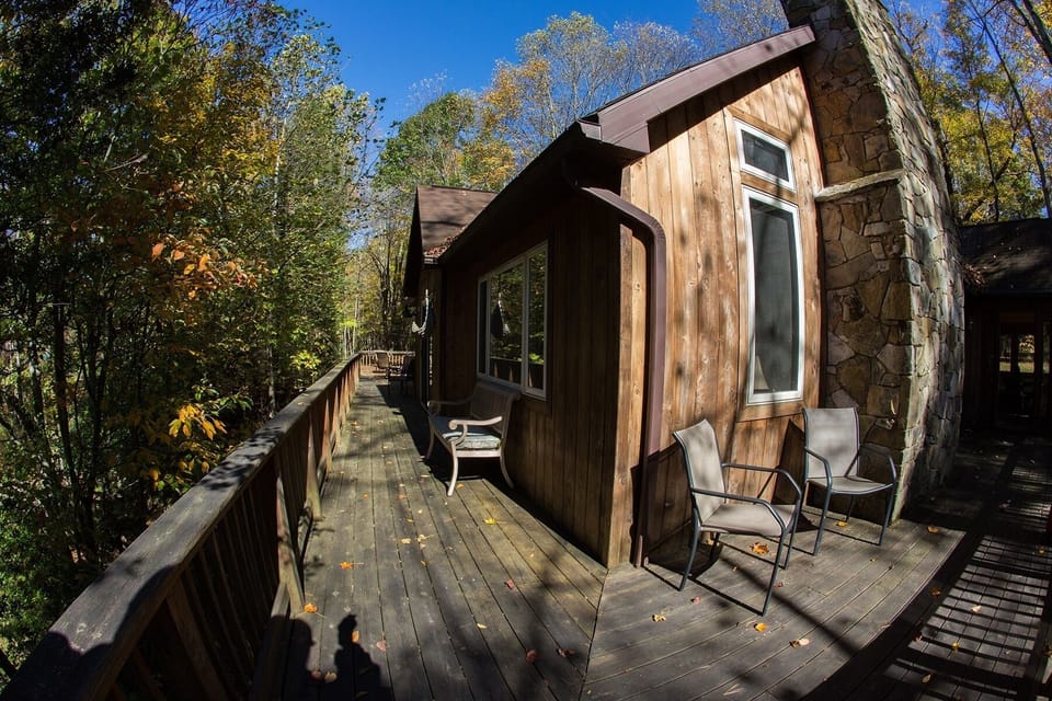 Huge wrap around deck with many quiet corners amidst the lush trees
