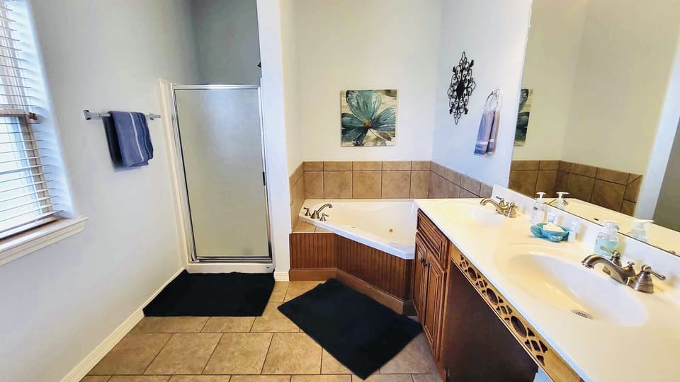 Master bathroom with a jacuzzi tub and walk in shower. En suite master bedroom