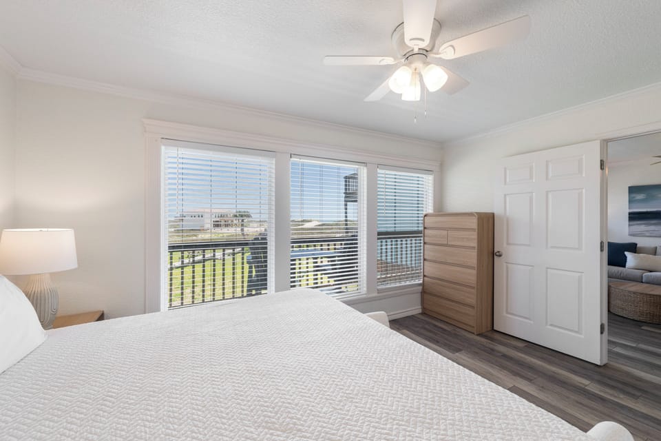 Drift off to sleep in your bright, airy bedroom with large windows overlooking the city. The ceiling fan keeps you cool while modern furnishings create comfort.