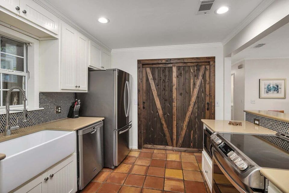White kitchen with farmhouse sink and rustic barn doors