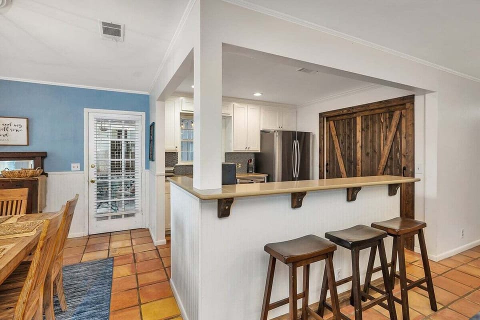 Open kitchen bar with wood stools and barn door accent
