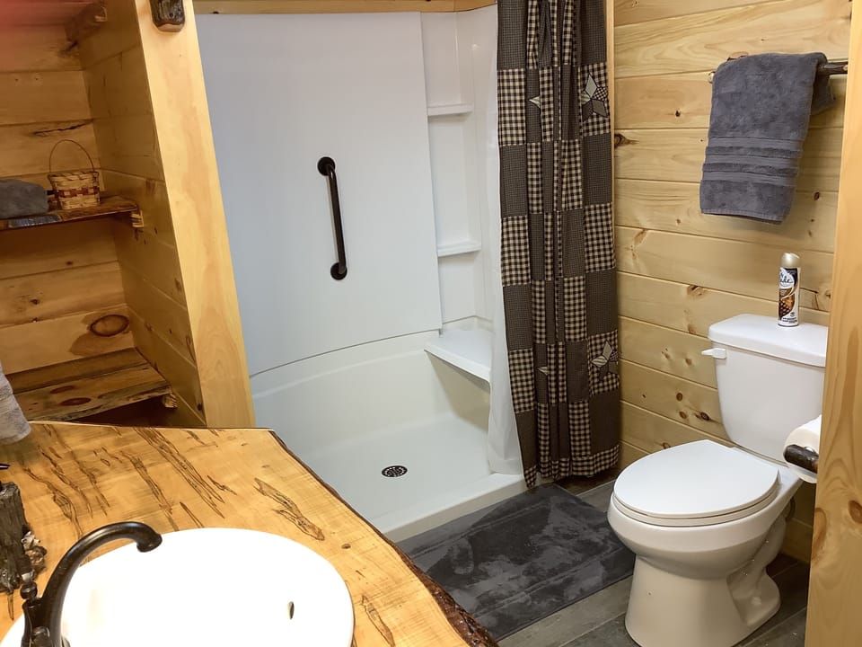 En suite master bath w/ handicap walk in shower w/ seat, handicap toilet, tile