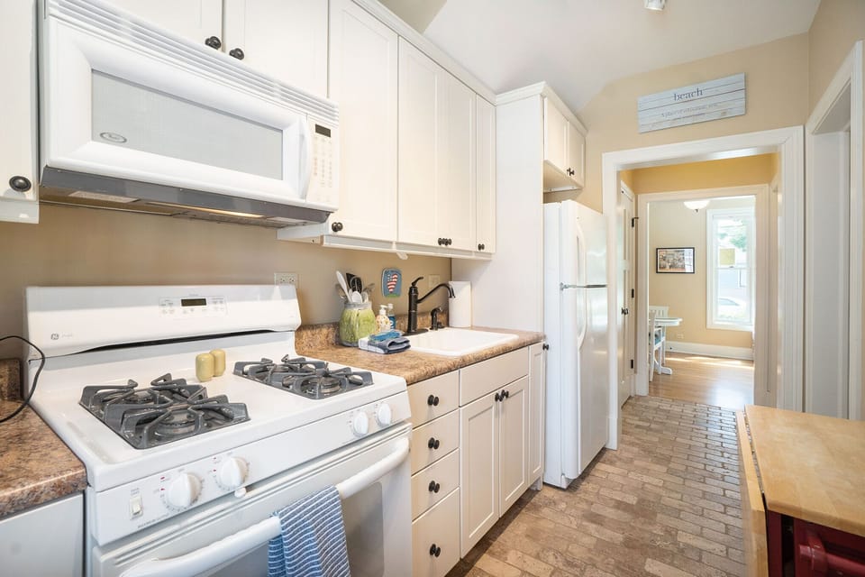 Kitchen with natural gas range and space saver microwave above. 