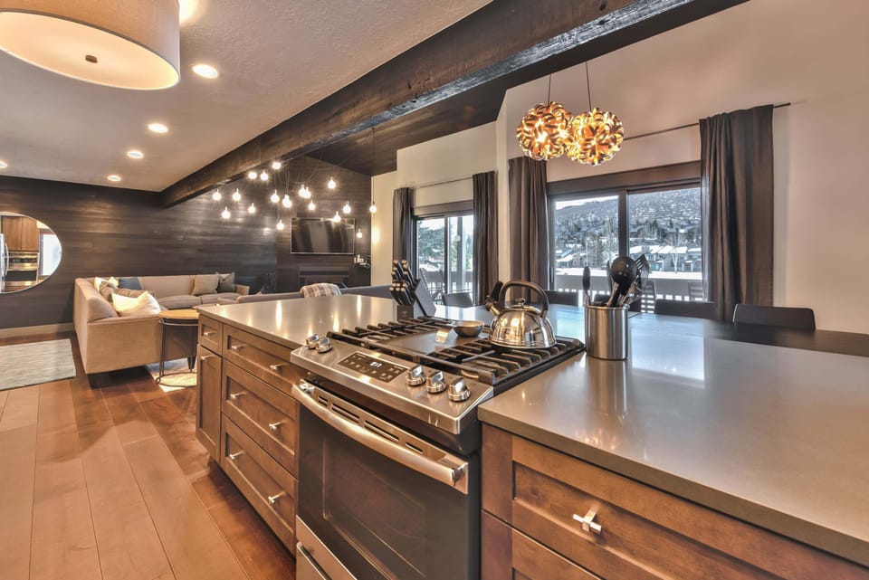 Fully-Equipped Kitchen with Stainless Steel Appliances, including a Gas Stove, Double Ovens, Quartz Countertops and Modern Decor