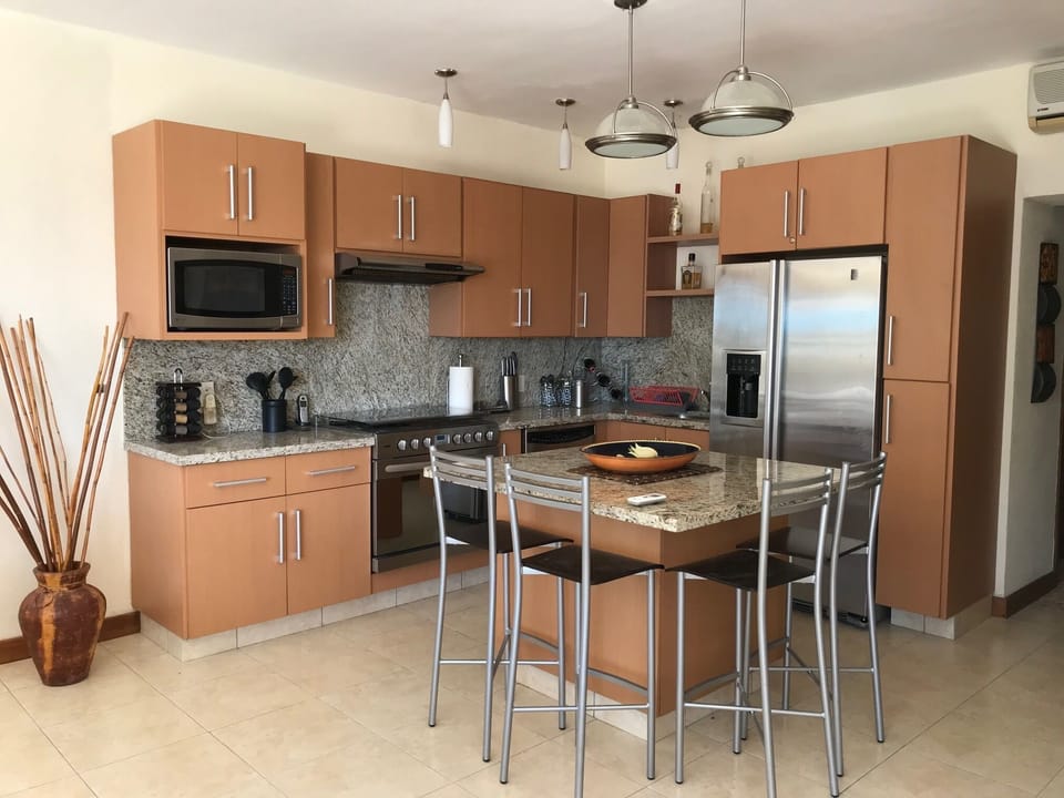 Fully equipped kitchen with 6 burner range, large oven, and double door fridge