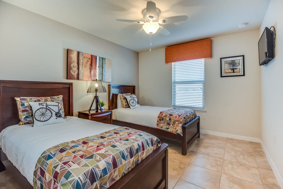 This bedroom with two beds offers a tranquil space for companionship and relaxation, where shared dreams and cherished moments intertwine amidst comfort and warmth.