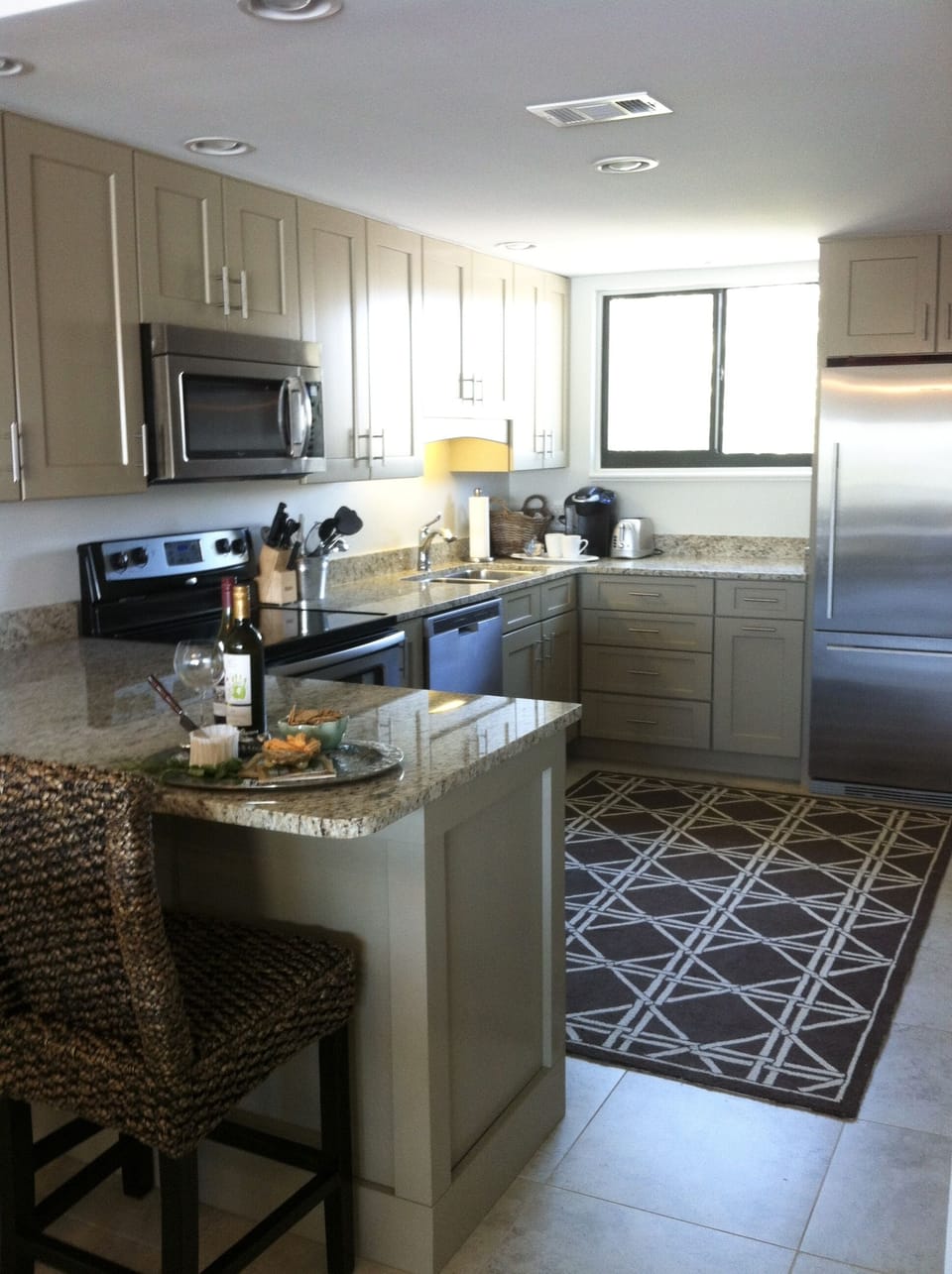 Kitchen fully stocked for cooking, stone countertops and stainless appliances