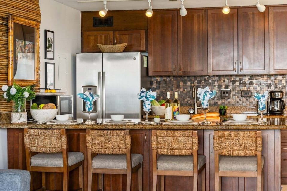 Fully equipped kitchen with granite countertops, modern appliances, and seating for four