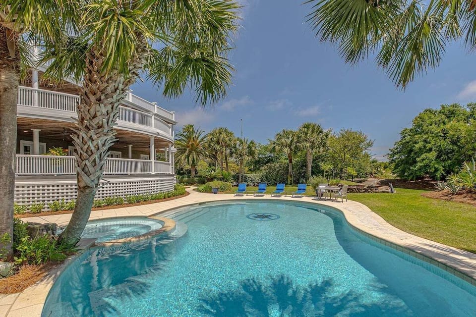 Pool with blue loungers and tropical palm trees