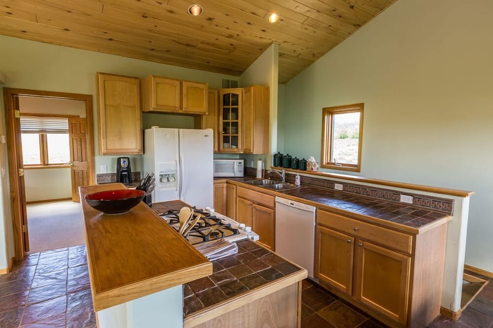 Fully equipped kitchen with natural stone floor and counter tops, gas stove 