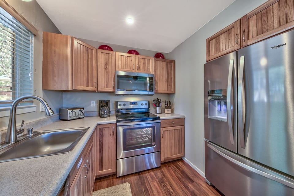 Kitchen with refrigerator with ice maker, electric stove/oven, microwave, dishwasher, and provided cooking basics