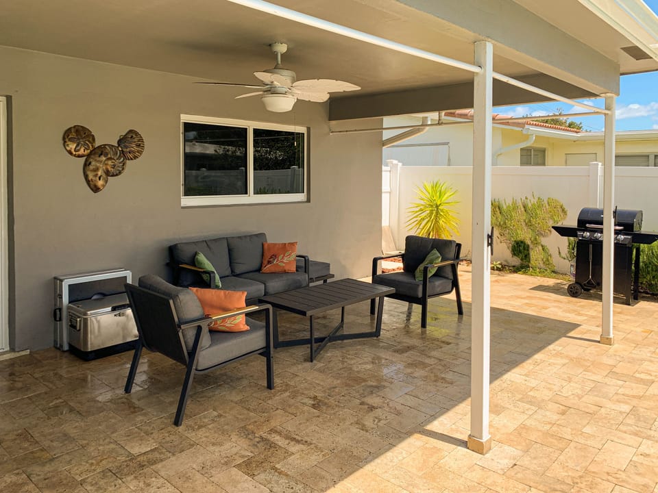 Covered Lanai with plenty of Seating and 4 burner Grill
