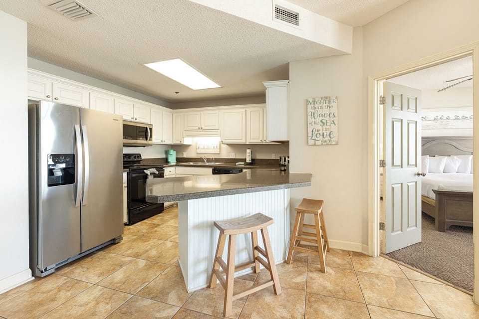 A bright kitchen with breakfast bar seating lets you sip morning coffee as you plan your beach day adventures