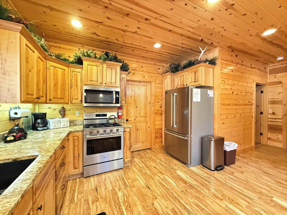 Enjoy modern cooking convenience surrounded by rich, authentic wood cabinetry and premium stainless steel appliances, including a spacious French-door fridge.