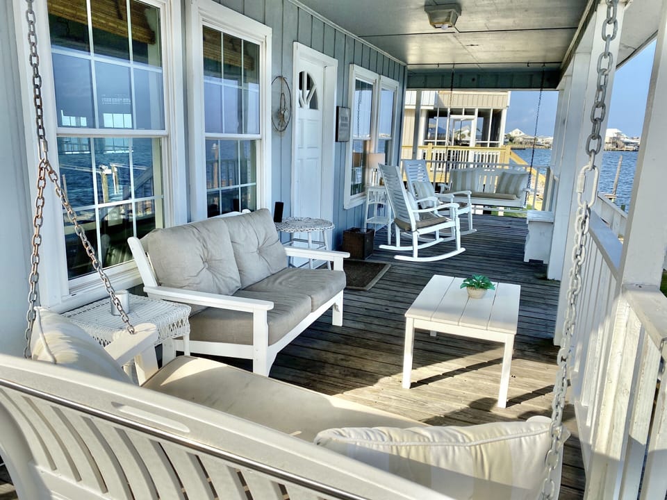 Upper deck features two swings, two rocking chairs, and a small sofa.