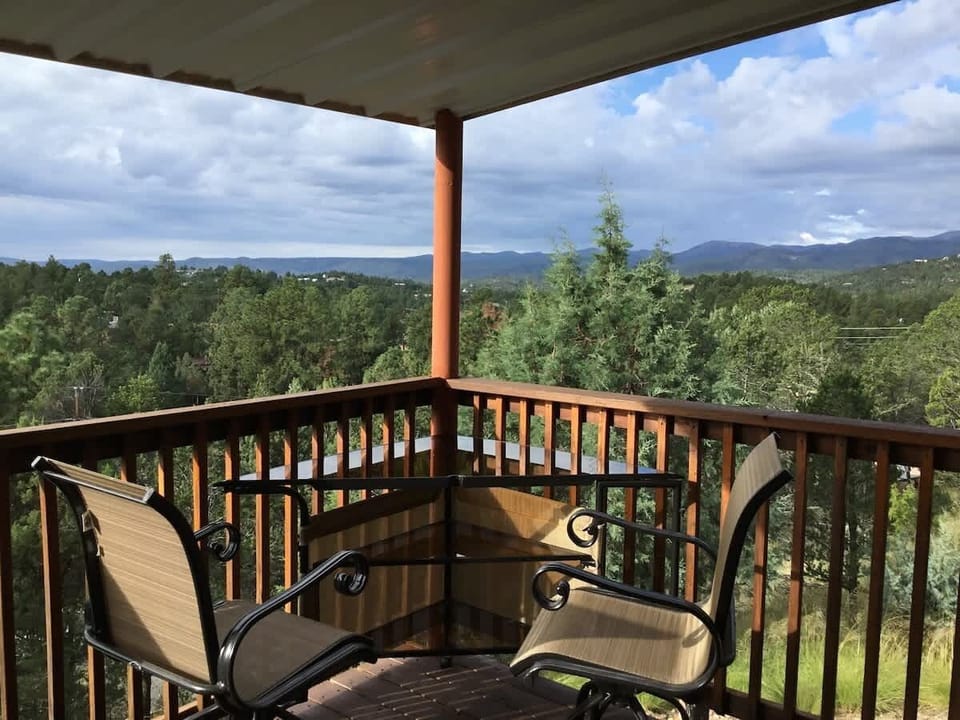 Covered wraparound deck with lounge seating and unobstructed mountain views.